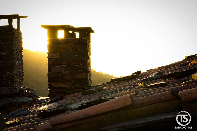 Chaminés e telhados de xisto no Talasnal ao final do dia
