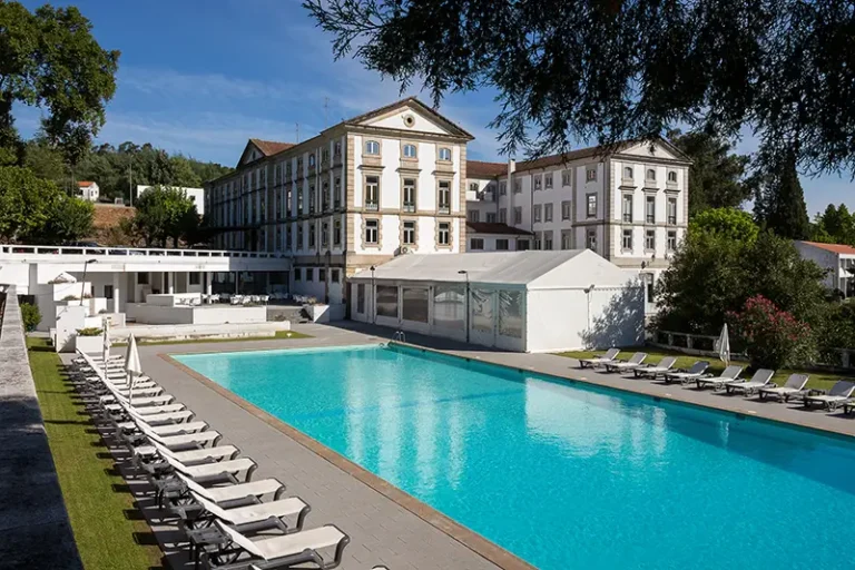 Grande Hotel das Caldas da Felgueira com piscina exterior rodeada de espreguiçadeiras, num ambiente sereno e verdejante.
