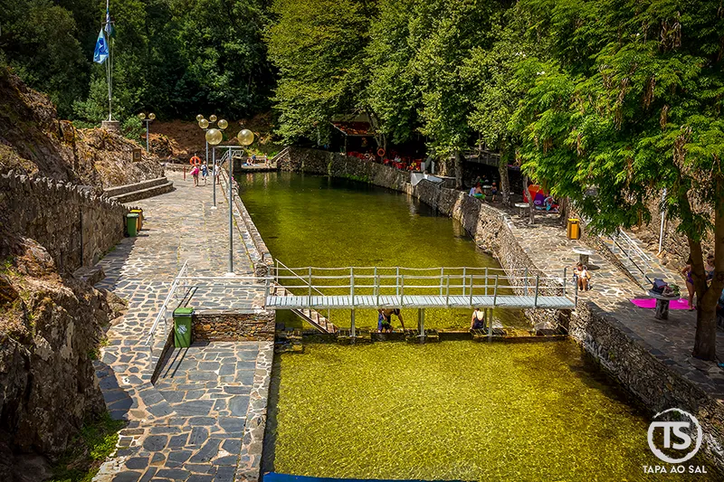 Praia Fluvial da Senhora da Piedade na Serra da Lousã com água verde e margens em pedra