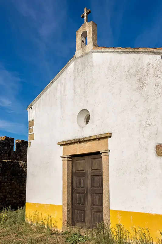 Fachada da Capela de São Brás no interior do Castelo de Belver, com céu limpo ao fundo