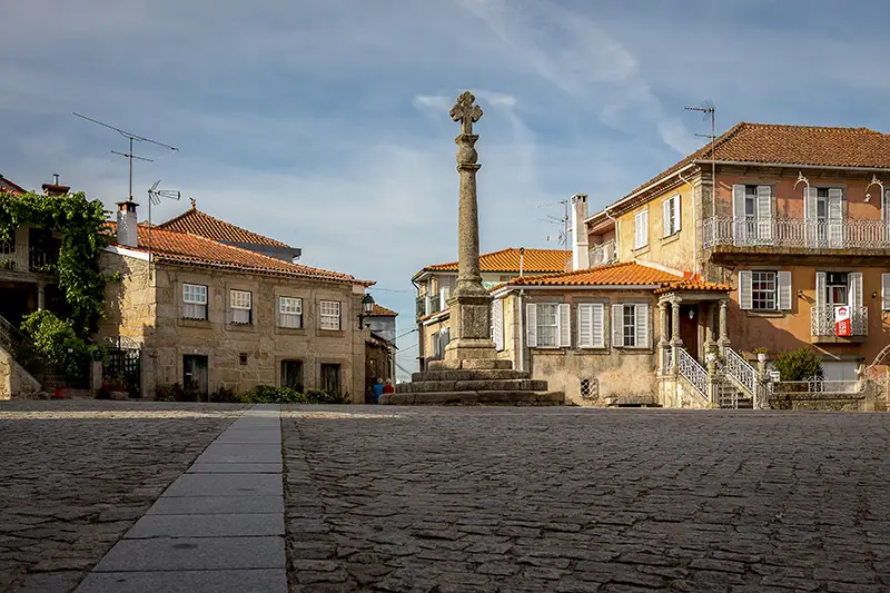 Cruzeiro no Largo do Paço em Santar, rodeado por casas históricas