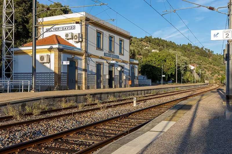Estação de comboios Belver-Gavião, ponto de acesso ao percurso pedestre PR1 – Arribas do Tejo, com linha ferroviária e edifício em estilo tradicional.