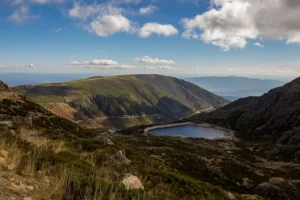Vista panorâmica da Serra da Estrela com lagoa de altitude e montanhas ao fundo — serra da estrela o que visitar