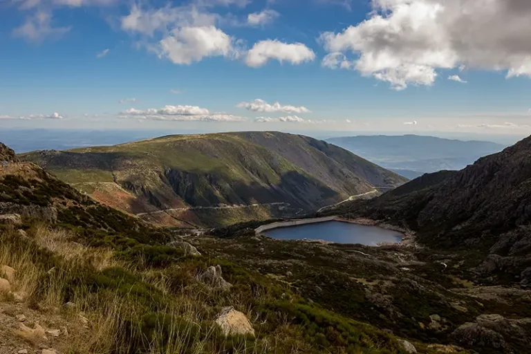 Vista panorâmica da Serra da Estrela com lagoa de altitude e montanhas ao fundo — serra da estrela o que visitar