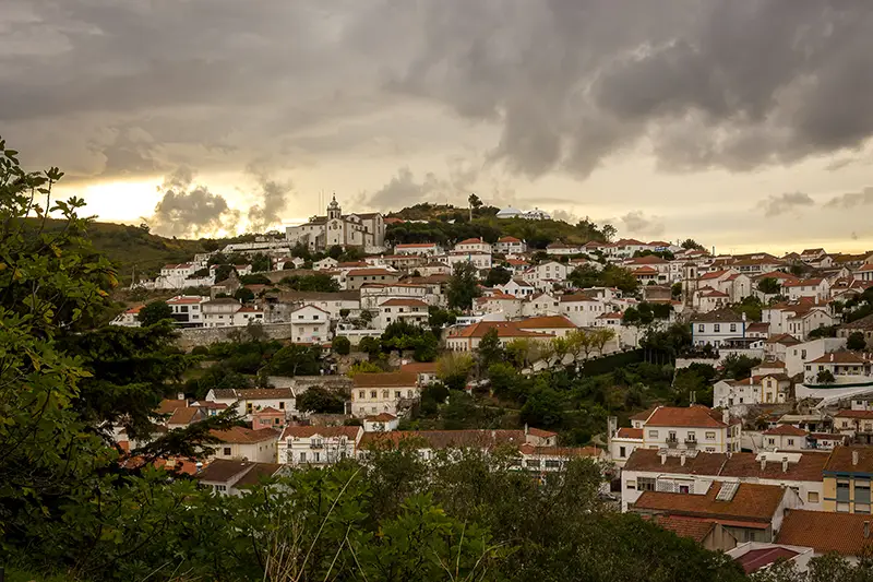 Vista de Alenquer ao final do dia com tons quentes sob um céu nublado.