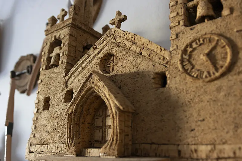 Igreja esculpida em cortiça, exemplo de artesanato português detalhado e criativo.