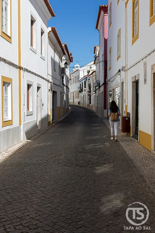 Rua estreita de Vila Viçosa com casas brancas e detalhes amarelos