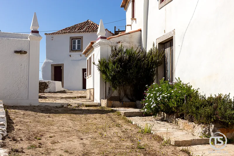 Rua típica nas Azenhas do Mar com casas brancas tradicionais.