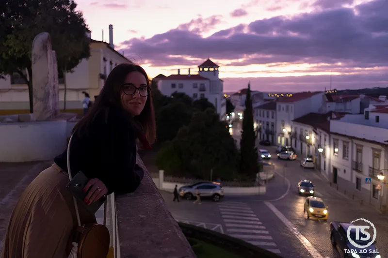 Vista de Évora ao entardecer com ruas iluminadas e muralhas no centro histórico
