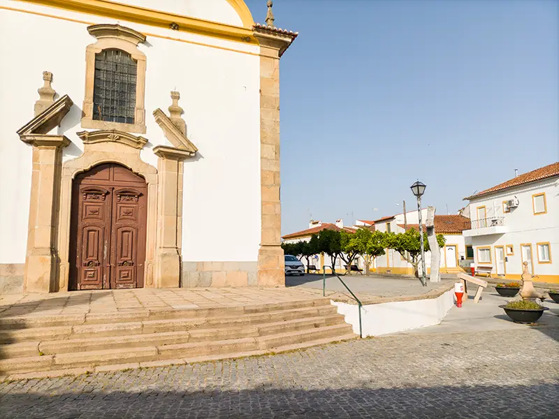 Entrada da Igreja Matriz de Alpalhão com escadaria em pedra e casario ao fundo – Alpalhão o que visitar