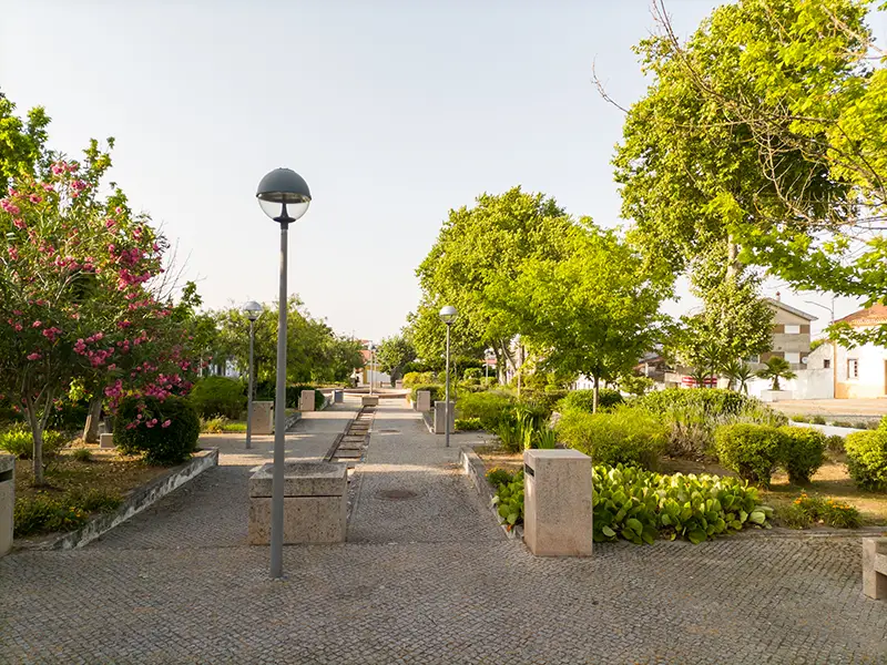 Jardim do Largo da Devesa em Alpalhão, com árvores verdes, caminhos em calçada e iluminação pública – Alpalhão o que visitar