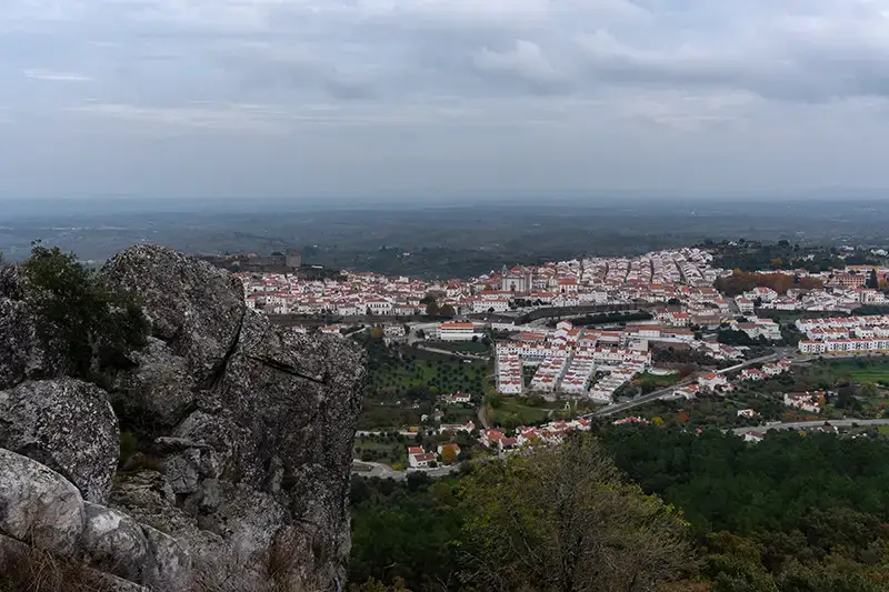 Vista ampla sobre Castelo de Vide a partir do alto da serra, com penedos no primeiro plano