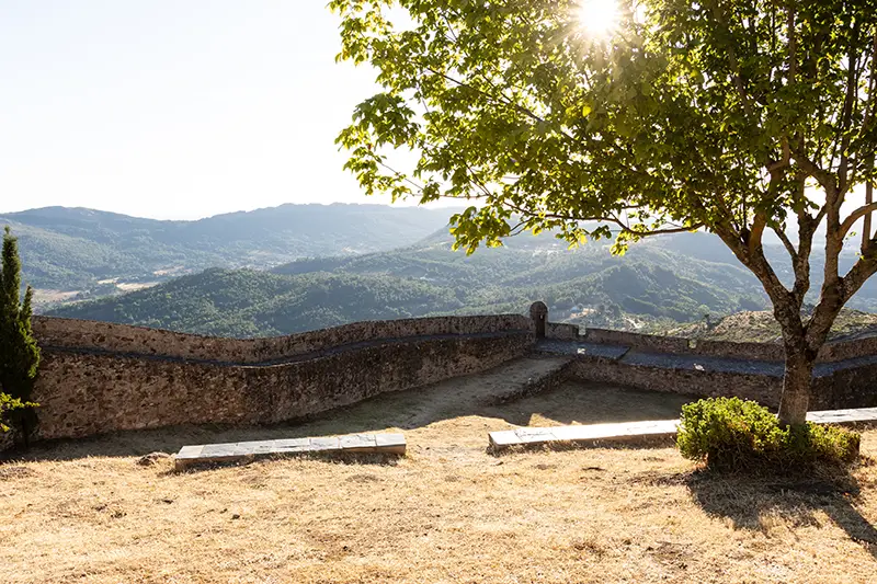 Vista desde as muralhas de Marvão com árvore em contraluz e paisagem montanhosa ao fundo
