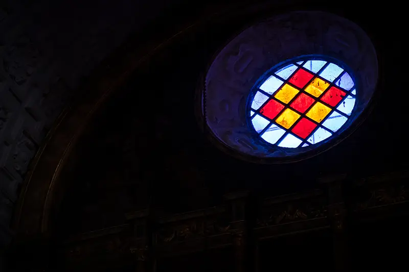 Vitral colorido da Sé Catedral de Portalegre com padrão geométrico azul, vermelho e amarelo
