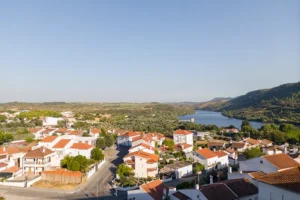 Vista panorâmica de Vila Velha de Ródão com o Tejo ao fundo e casas de telhado vermelho em primeiro plano