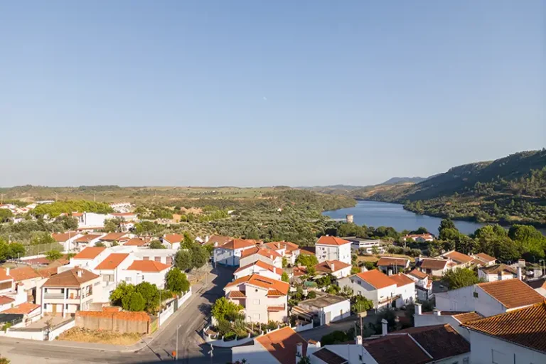 Vista panorâmica de Vila Velha de Ródão com o Tejo ao fundo e casas de telhado vermelho em primeiro plano