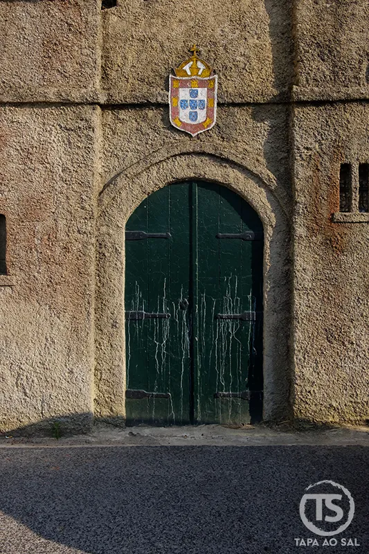 Porta antiga com brasão português na entrada da Aldeia José Franco em Mafra