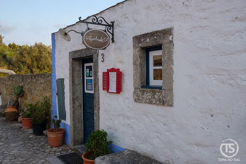Entrada da Tasquinha do Gil na Aldeia da Mata Pequena com fachada branca e detalhes rústicos