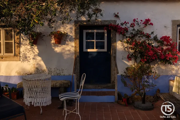 Porta azul e buganvílias na Aldeia da Mata Pequena ao entardecer