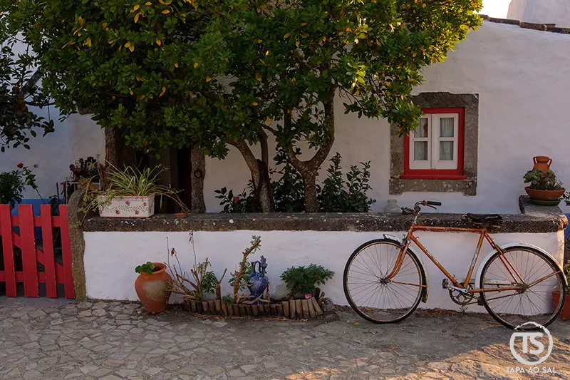 Bicicleta antiga encostada a muro branco na Aldeia da Mata Pequena