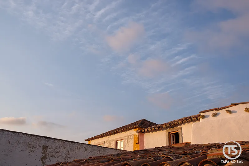 Telhados de barro e casas caiadas na Aldeia da Mata Pequena ao pôr do sol