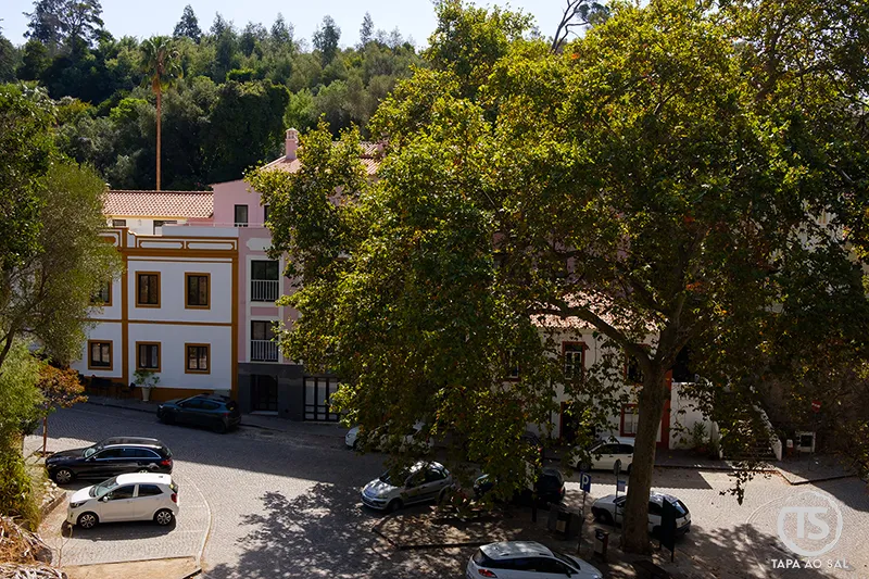 Praça central das Caldas de Monchique com edifícios históricos e árvores sombreadas