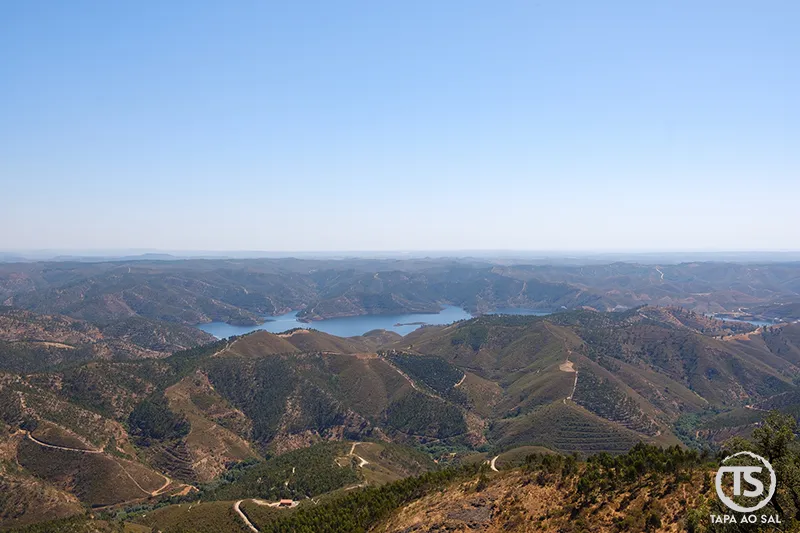 Vista panorâmica da serra de Monchique a partir do Castelo de Alferce, com o reflexo da barragem ao fundo.