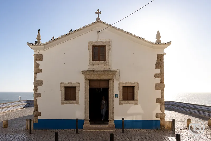 Ericeira o que visitar Capela de São Sebastião voltada ao mar com fachada branca e detalhes em pedra