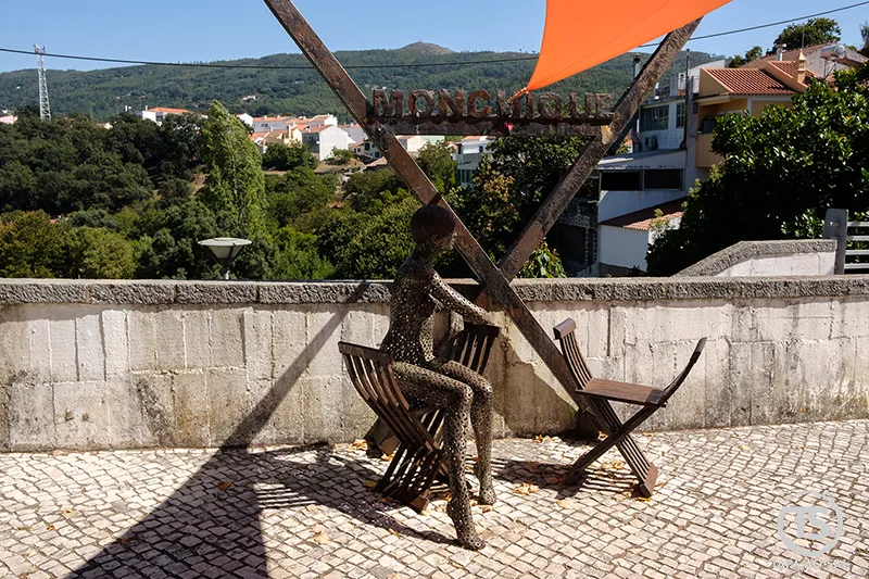 Escultura em ferro junto a cadeiras de tesoura em Monchique com vista para a serra