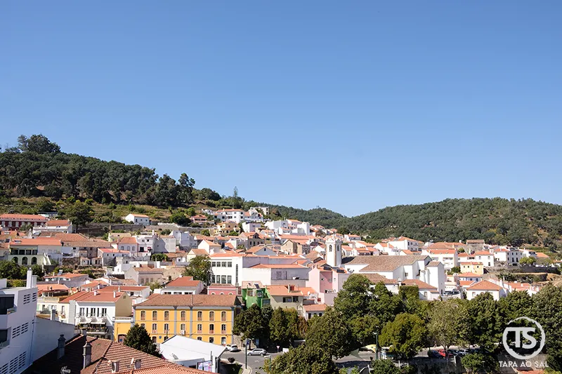 Vista panorâmica da vila de Monchique com casas coloridas e serra verdejante ao fundo