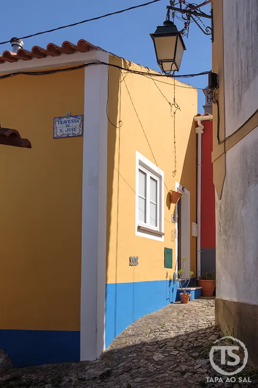 Travessa de São José em Monchique com casas coloridas e rua de calçada estreita