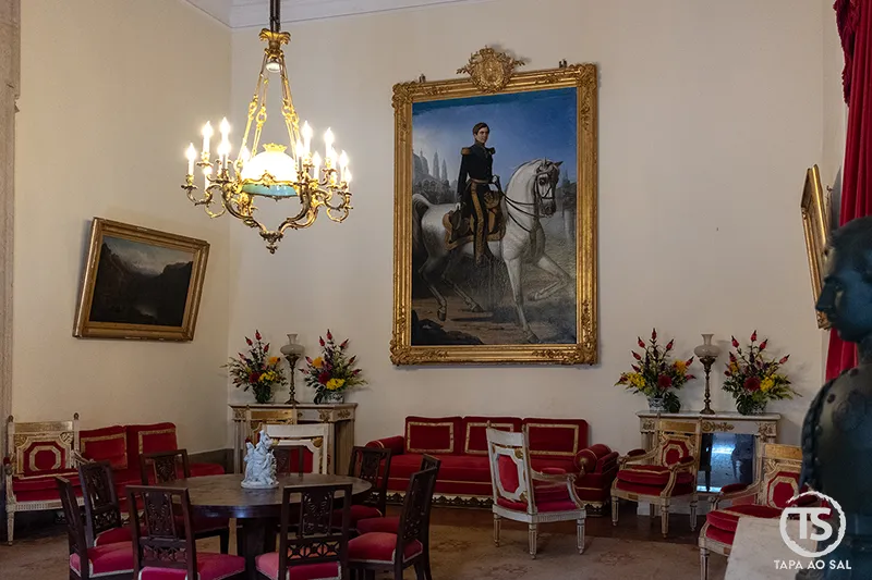 Sala dos aposentos reais do Palácio Nacional de Mafra com mobiliário histórico e retrato emoldurado