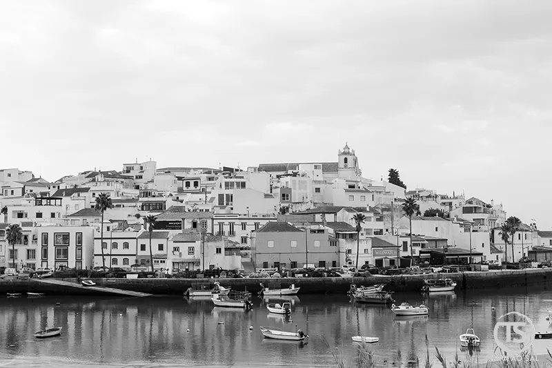 Vista panorâmica de Ferragudo refletida no rio Arade com barcos ancorados