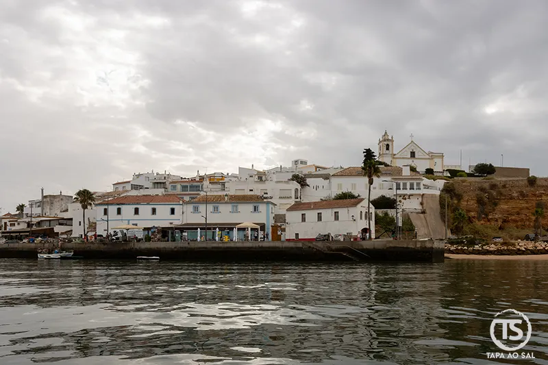 Vista de Ferragudo com a Igreja de Nossa Senhora da Conceição junto ao cais e reflexos no rio Arade