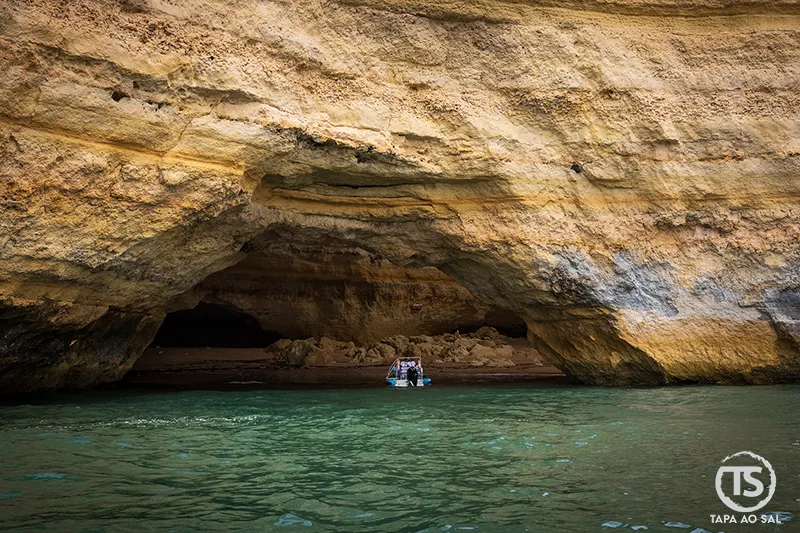barco turístico a entrar nas Grutas de Benagil pelas falésias de calcário do Algarve