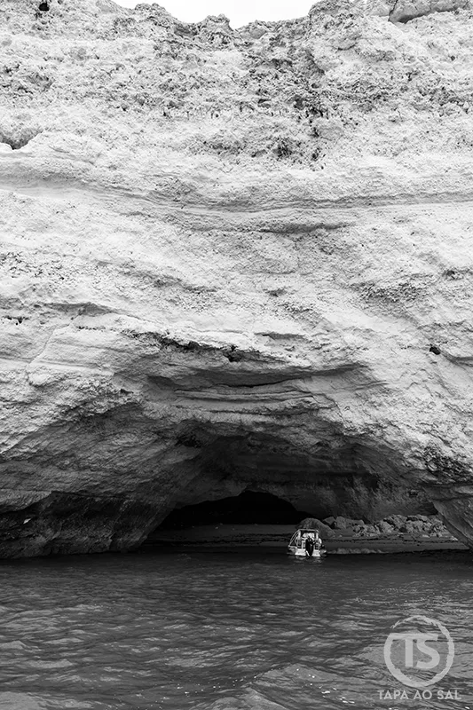 entrada das Grutas de Benagil vista do mar com barco a aproximar-se da caverna