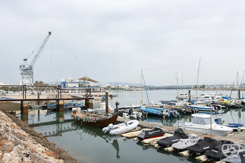 Marina de Portimão no rio Arade com veleiros, barcos e estrutura portuária, zona ribeirinha a visitar em Portimão
