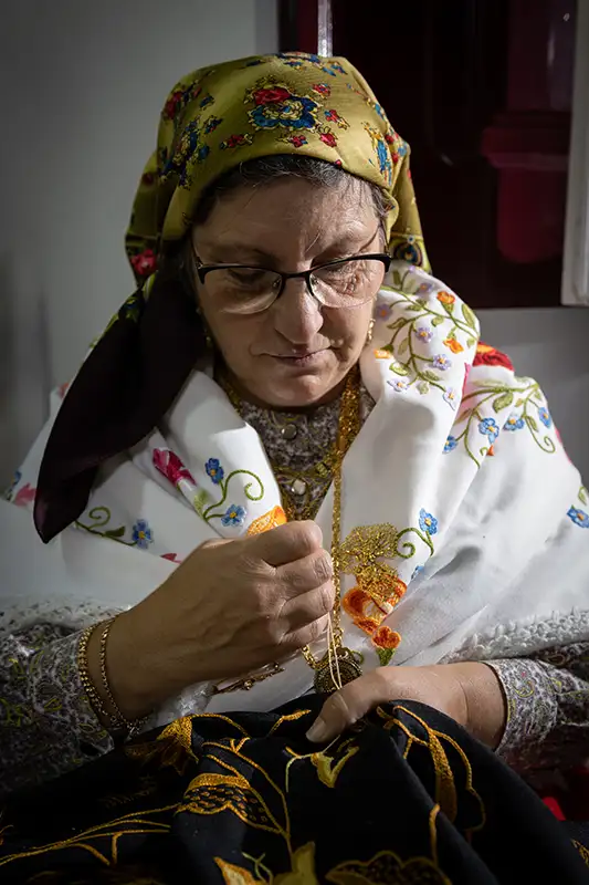 Artesã portuguesa a trabalhar bordados tradicionais, representando a cultura em Portugal