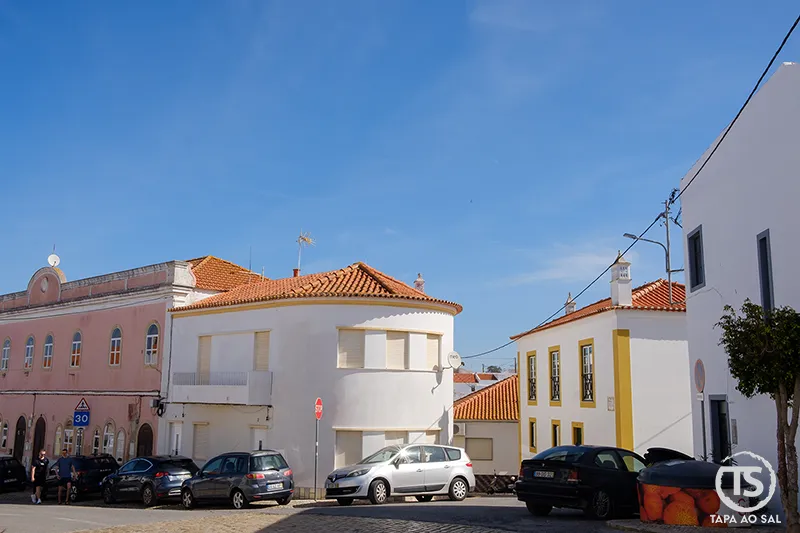 Praça central de Alcantarilha com casas tradicionais e carros estacionados