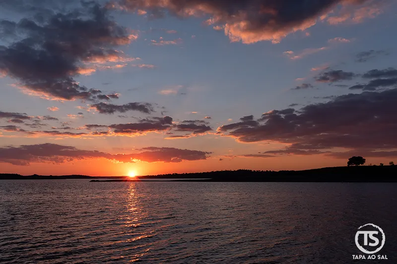 pôr do sol sobre a água no Alentejo com céu colorido, experiências que não deves perder
