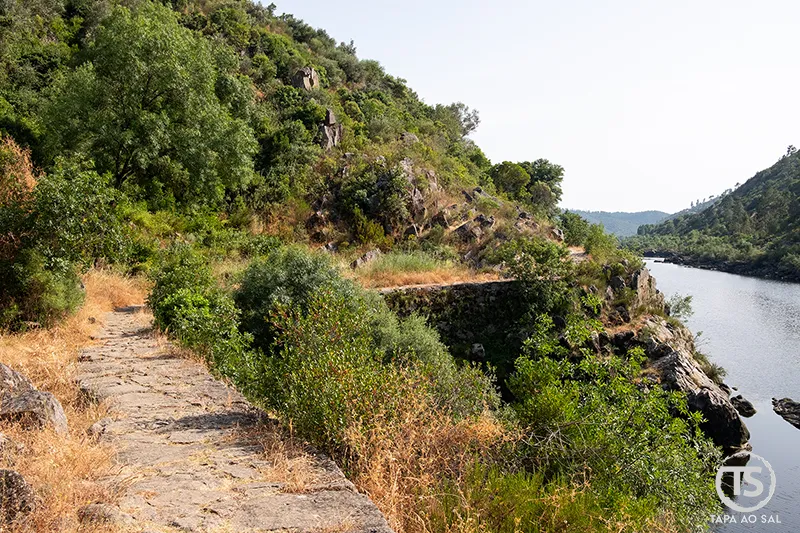 trilho junto ao rio entre encostas verdes no Alentejo, natureza trilhos e património megalítico