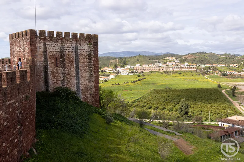 Muralhas do Castelo de Silves com torre em arenito vermelho e vista sobre o vale do rio Arade no Algarve