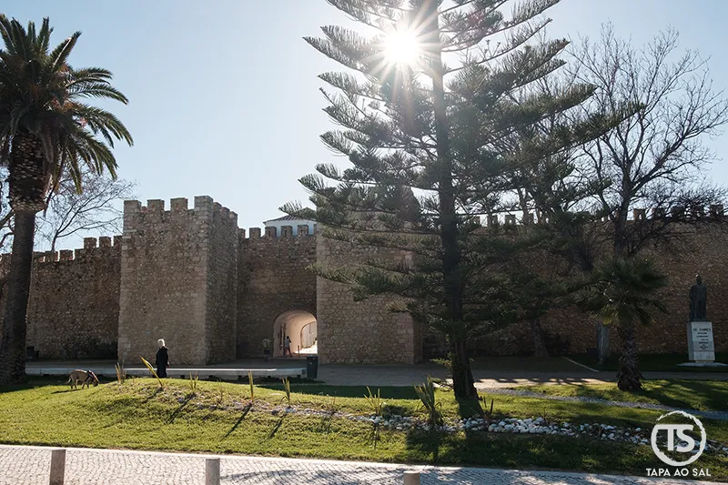 Muralhas de Lagos com porta fortificada e jardim ao entardecer no Algarve