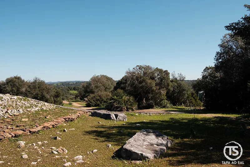 Paisagem envolvente do monumento megalítico de Alcalar com pedras expostas junto ao percurso arqueológico