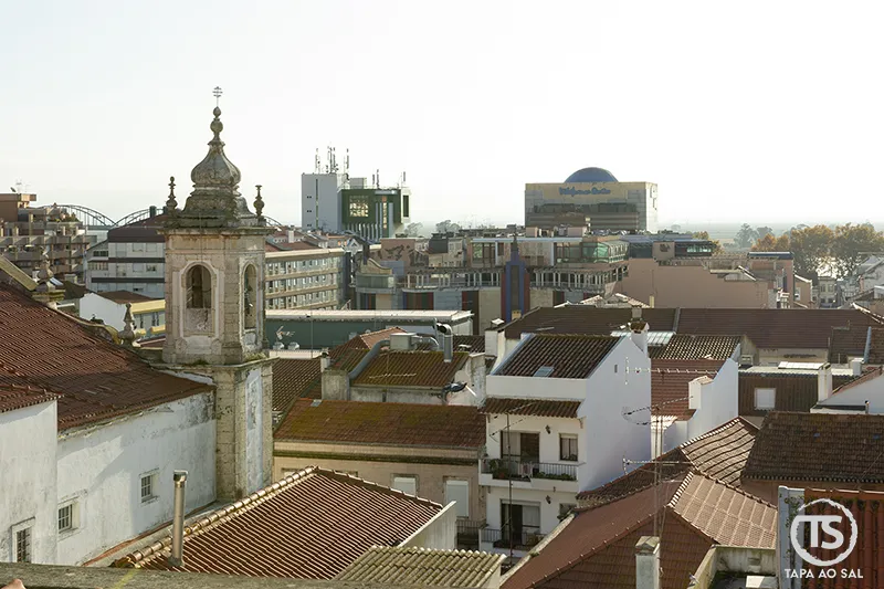 Vista urbana de Vila Franca de Xira com campanário, telhados e edifícios ao fundo